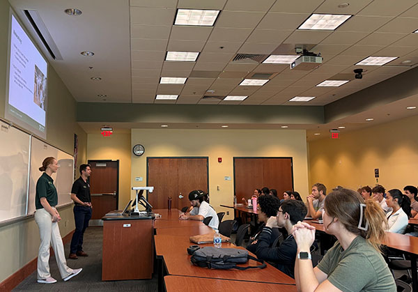 two instructors in front of a class of students